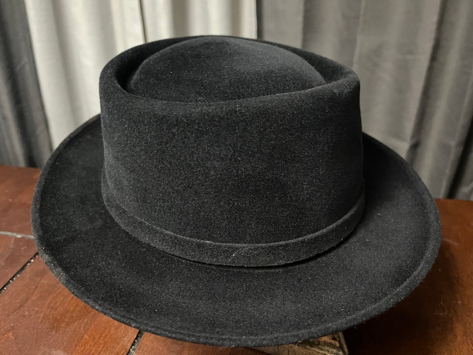 Black Dobbs hat after the first shaping into a low-crowned pork pie.