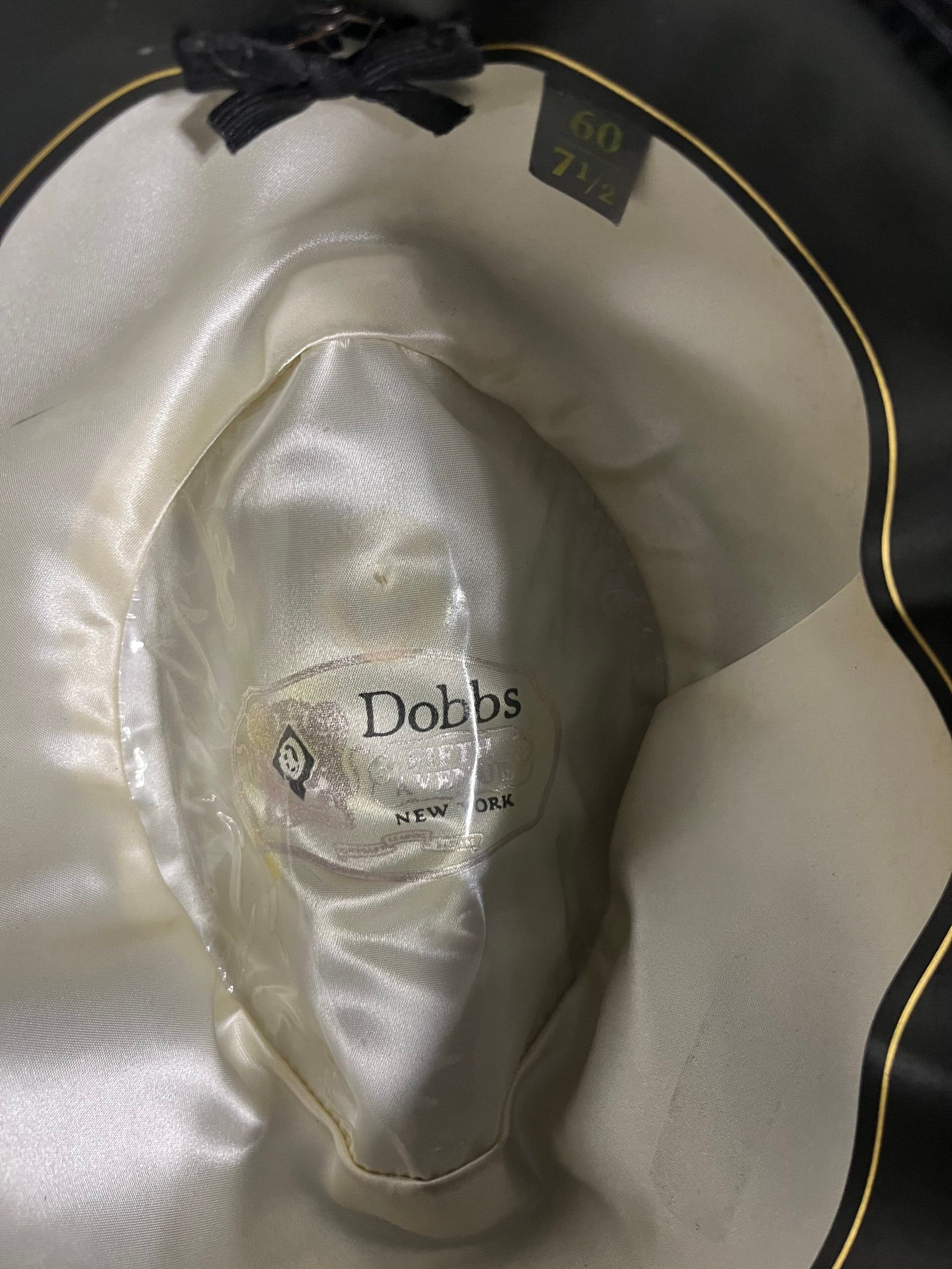 Original interior of the vintage Dobbs fedora showing the cream liner, Dobbs logo, sweatband, and size tag.