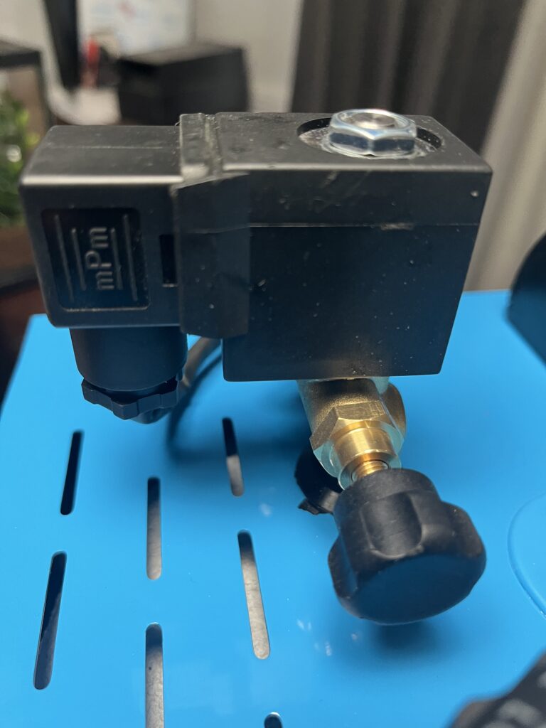 Close-up of ST-750 steam-adjustment valve and control knob mounted beside the steam solenoid assembly