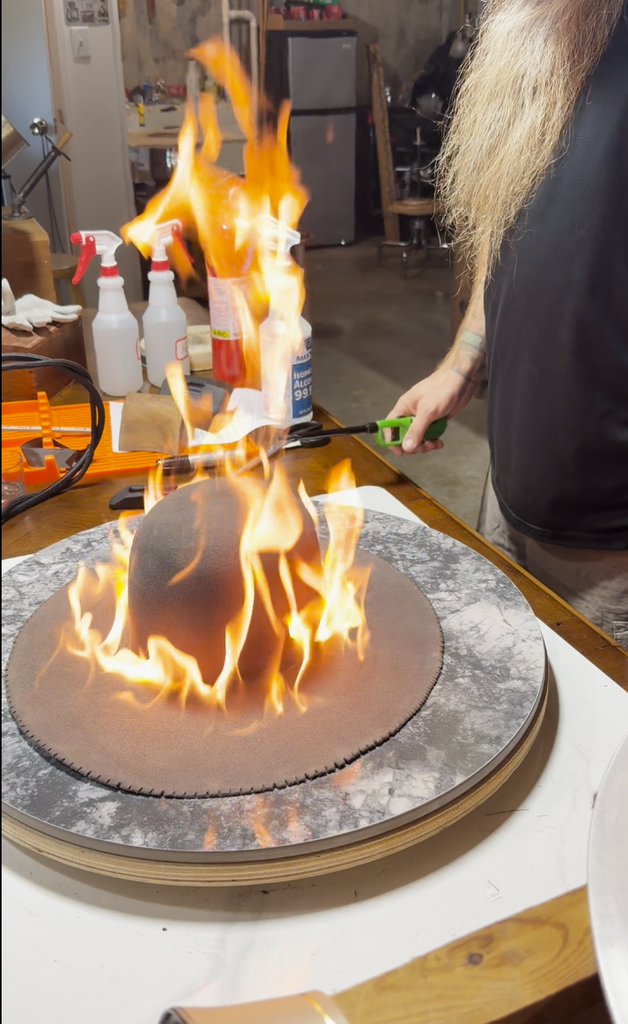Firing the surface of the 100% beaver felt during finishing of Project PM-26-011.