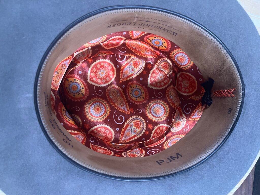 Interior of Project PM-26-011 showing the leather sweatband, decorative seam and bow, and patterned liner.