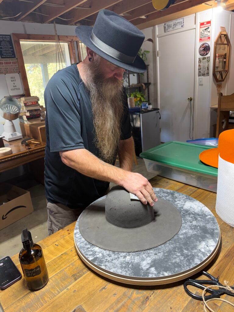 Pouncing the crown of the 100% beaver felt body during construction of Project PM-26-011.